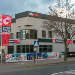 Flagi z logotypem przy kompleksowym oznakowaniu budynku